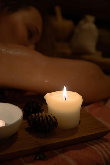 massage bien-être thérapie psycho-corporelle Mains posées délicatement sur le dos d'une personne lors d'un massage bien-être, ambiance apaisante, lumière chaude et bougies